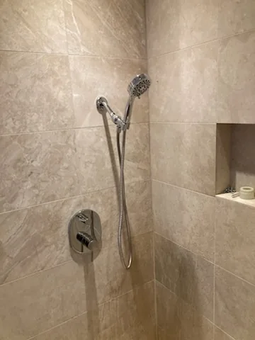 The finished tiled shower with its mixer and rail
