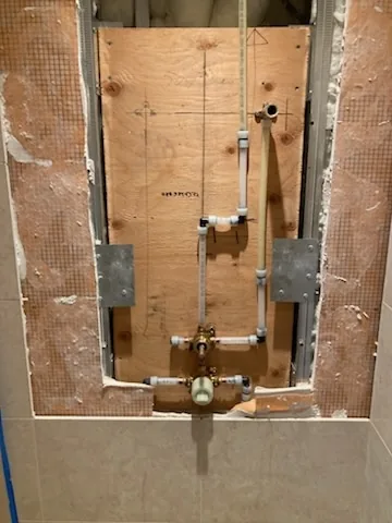 A shower valve roughed in on the open wall, before tiling