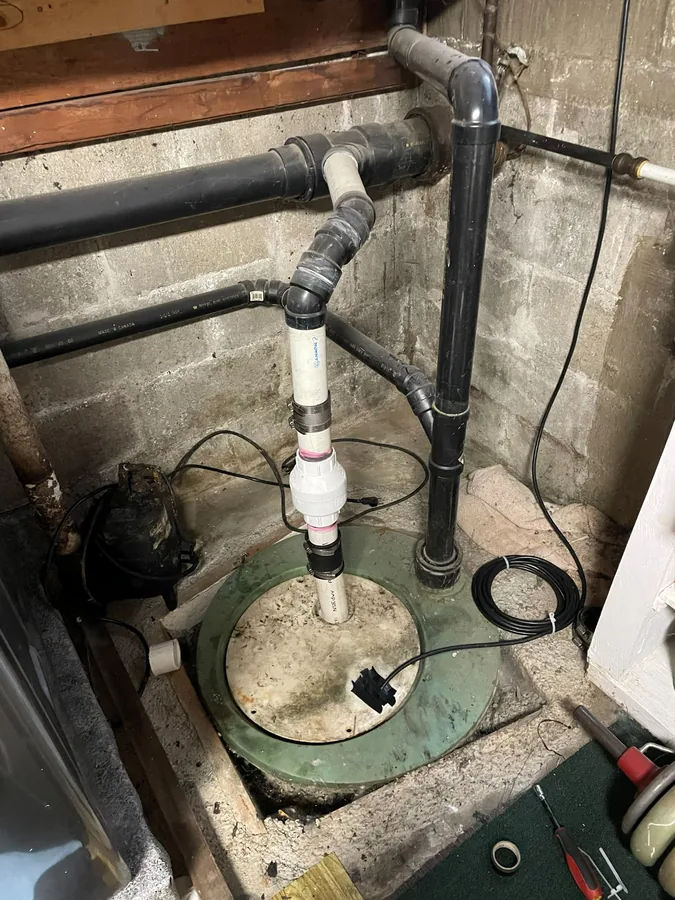 The old sump pump and its pipework in the pit